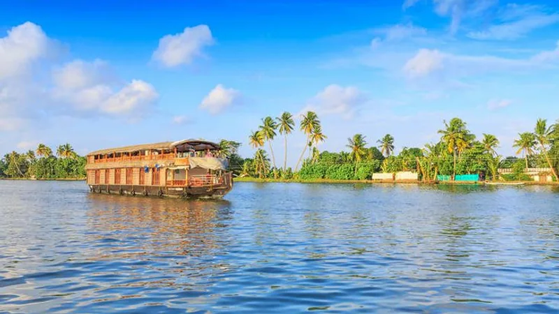 A traditional Kerala houseboat cruising past palm-fringed banks on the Alleppey backwaters